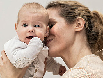 Osanit Familie: Baby und Mama kuscheln